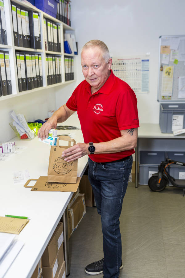 Apotheken Sibbel - Mitarbeiter beim Einpacken von Medikamenten